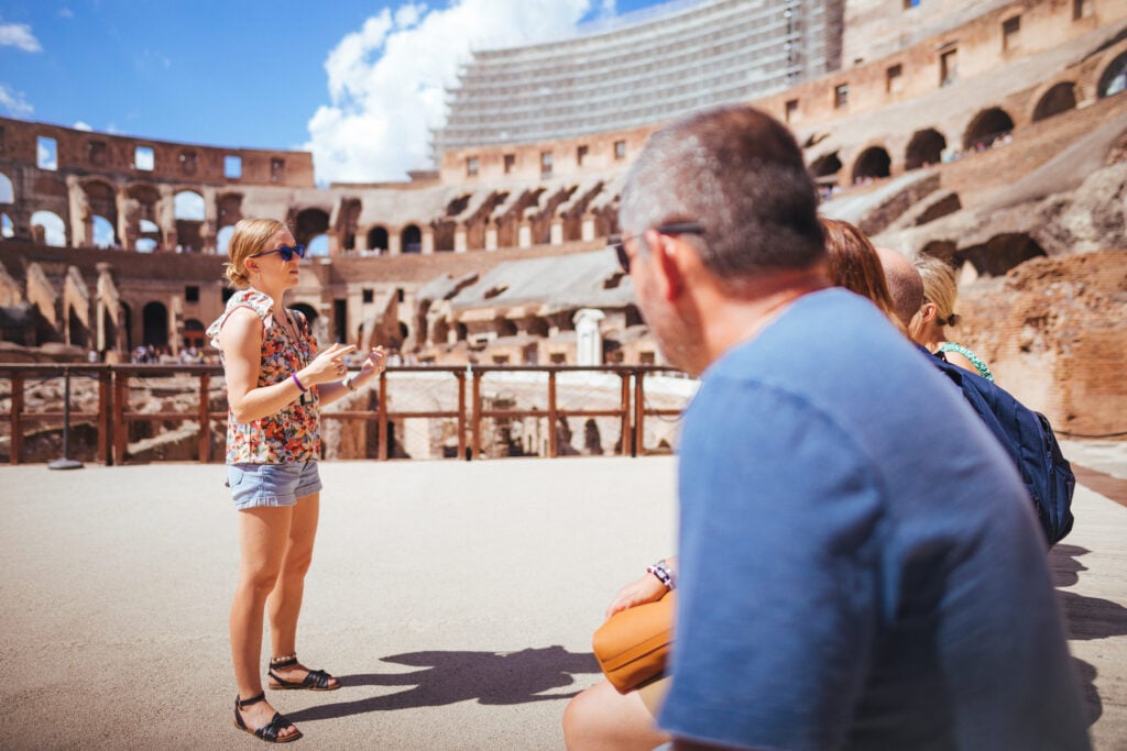 Local guide explaining to a small group tour the history of the Colosseum Arena