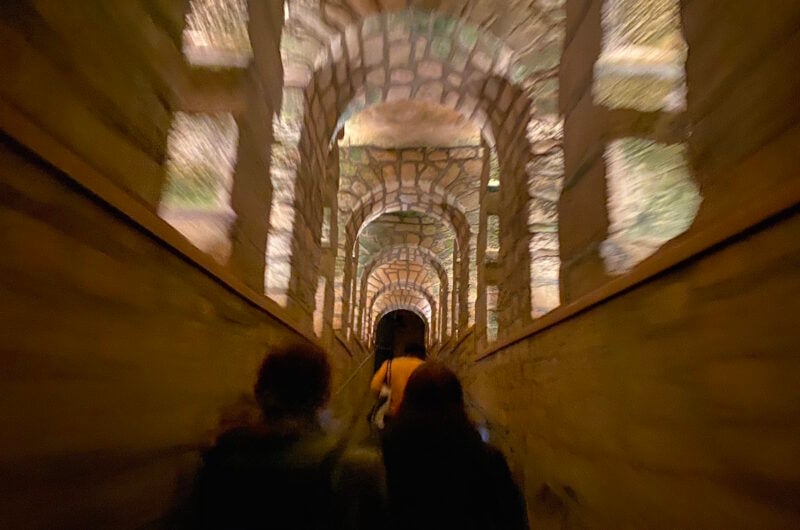 a person walking underground in the Paris catacombs