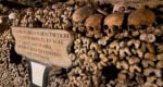 skulls and bones piled around an inscription