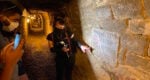 a guide showing an inscription on a wall
