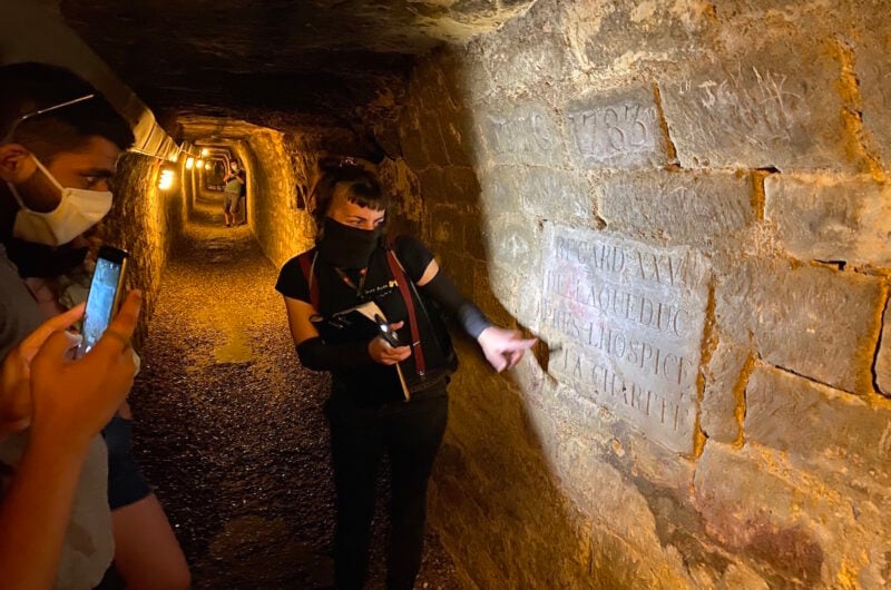 a guide showing an inscription on a wall