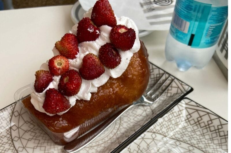 a cake covered in cream and raspberries