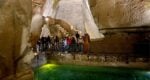 a pool of green water inside a cave