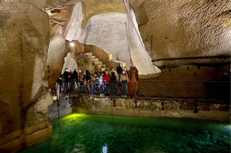 a pool of green water inside a cave