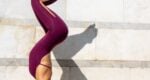 Woman in an inverted yoga pose outside