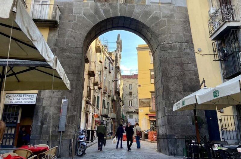 a large brick archway with some people beneath it