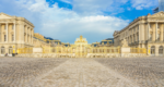 Exterior view of the Palace of Versailles taken outside the gold entrance gate