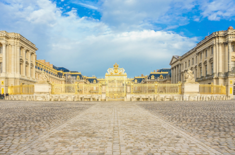 Exterior view of the Palace of Versailles taken outside the gold entrance gate