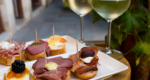 2 glasses of white wine, a plate with snacks in Venice