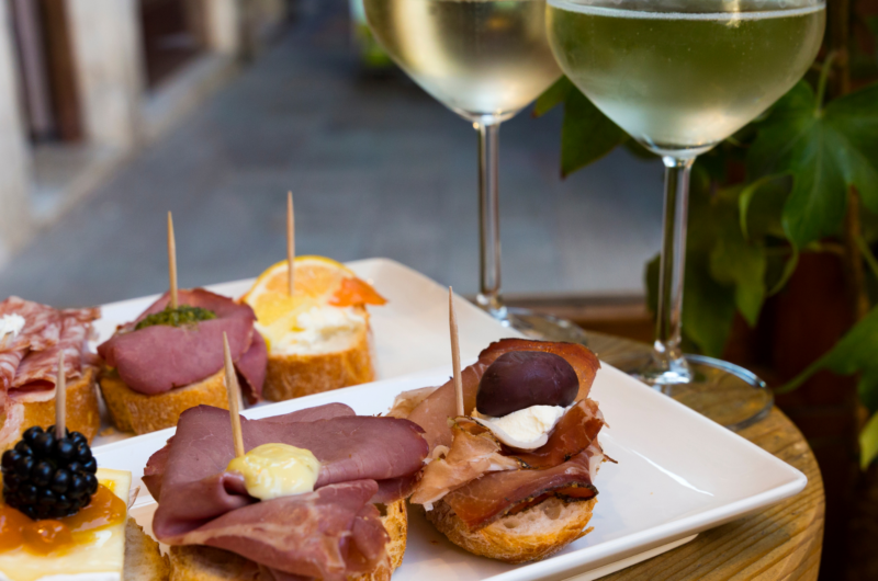 2 glasses of white wine, a plate with snacks in Venice