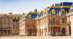 Exterior view of one wing of the Palace of Versailles made of red brick with a blue roof