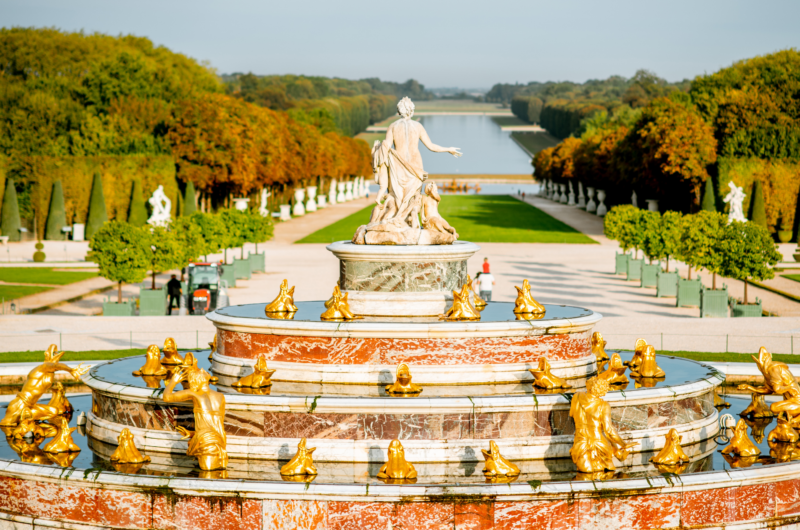 A grand fountain in the Gardens of Versailles with gold figures and many frogs
