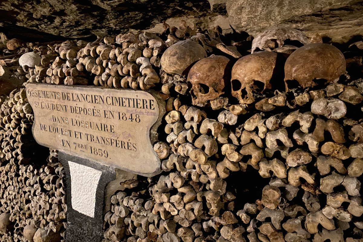 skulls and bones piled around an inscription
