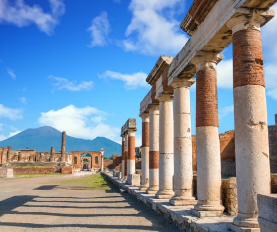 a road in Pompeii with a row of columns on one side