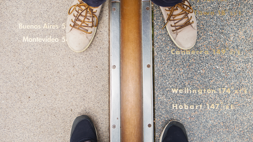 2 people standing on the Meridian Line in Greenwich, London