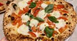 a pizza with tomatoes, mozzarella and basil