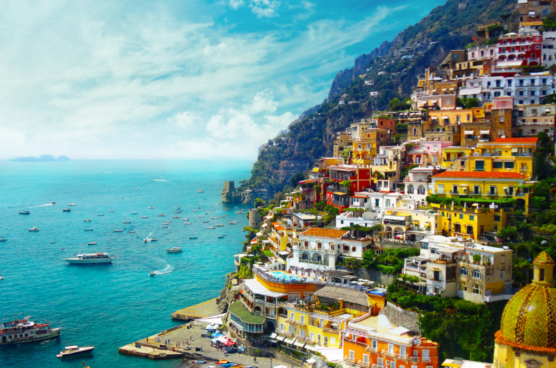 A town of colored houses on a hillside in front of the sea in Italy