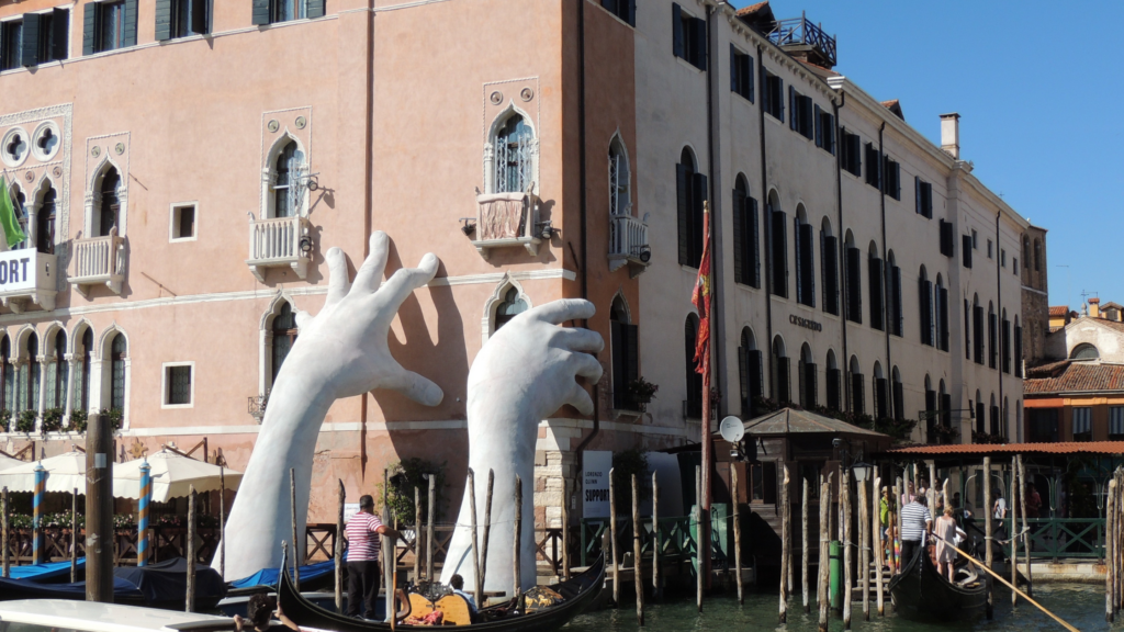 large sculpture of hands supporting a building in Venice