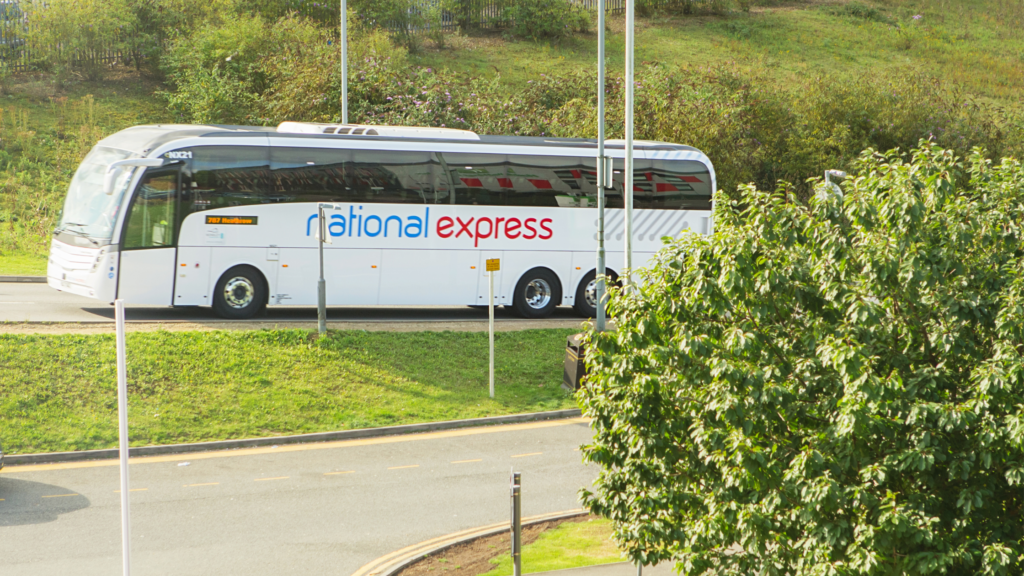 a white coach driving up a hill