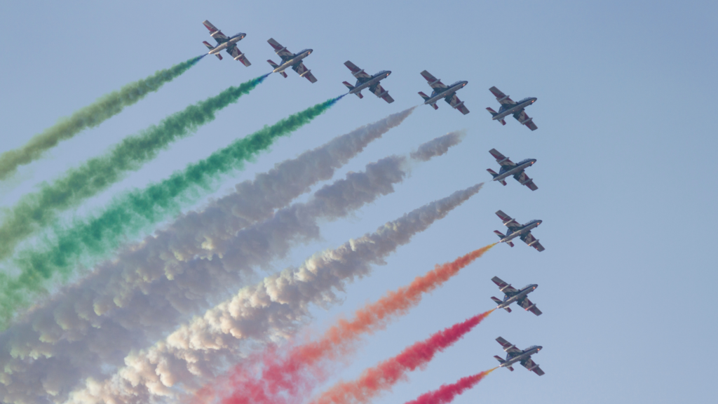 airplanes flying in formation with red, white and green smoke