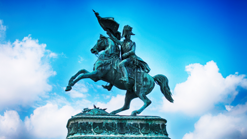 metal statue of a man on a horse holding a flag