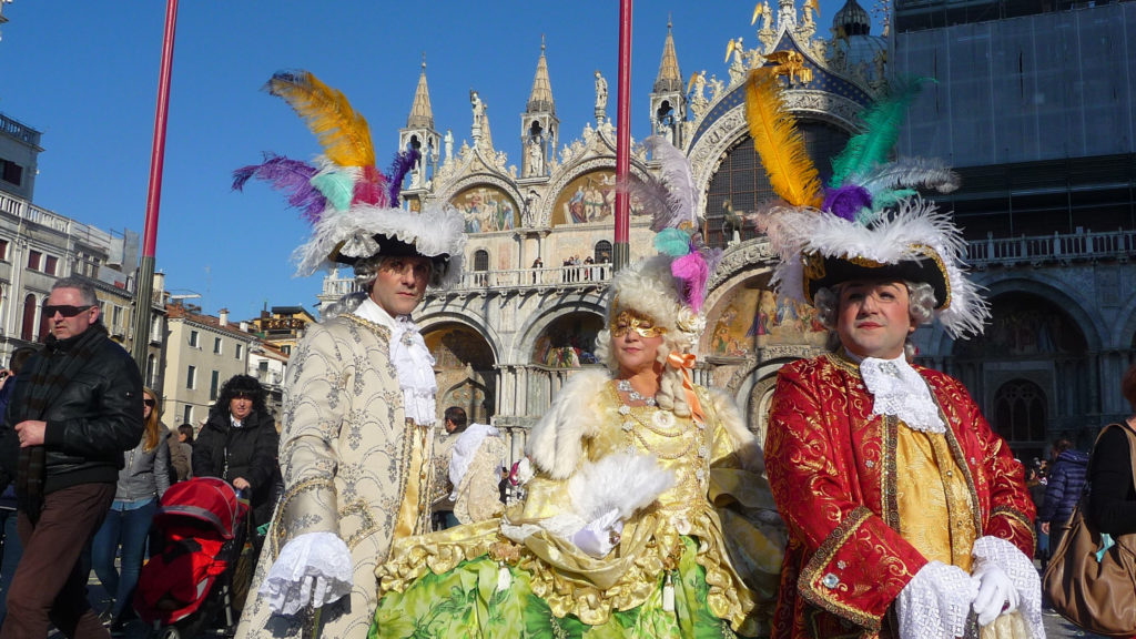 3 people in carnival costumes in front of St. Mark's Basilica, Venice