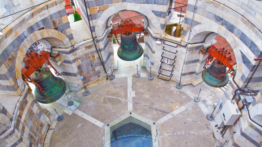 3 large metal bells inside a circular tower